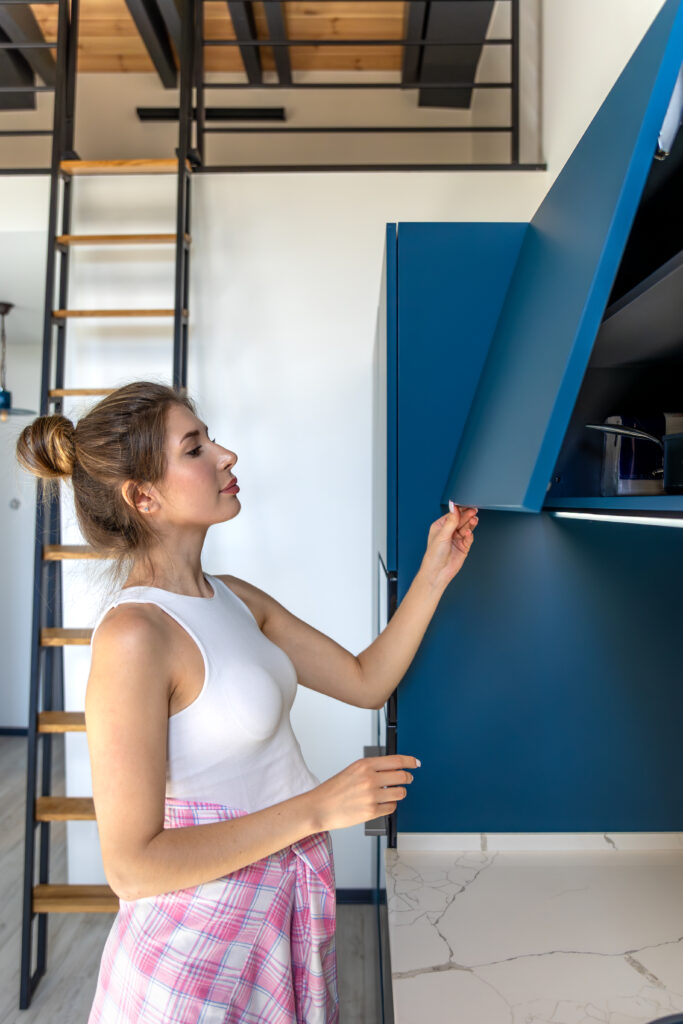 Woman opens cabinet. Kitchen organization. Stylish home